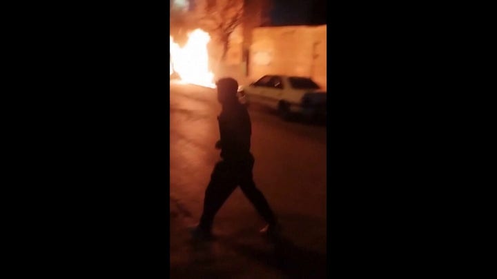 Iranian protesters chanted as car overturned, and fires burned outside the police station. Footage released on New Year